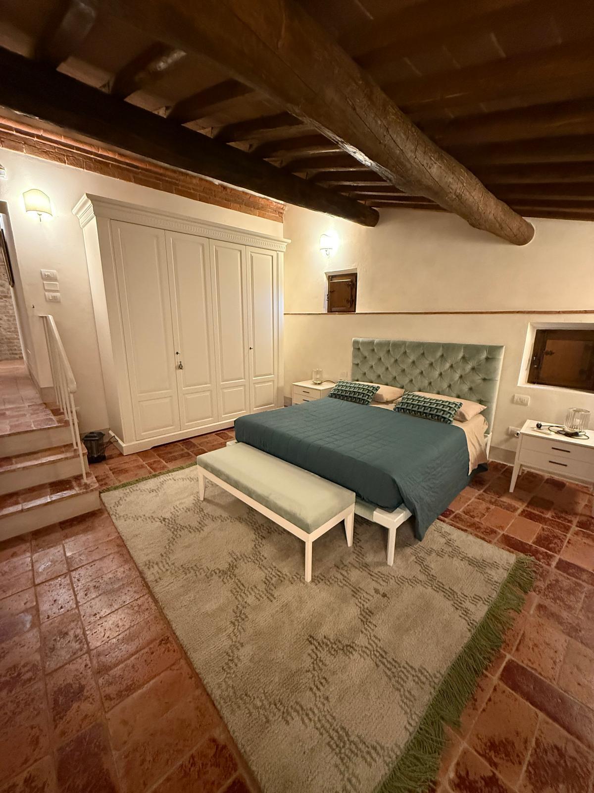 Schlafzimmer mit Holzbalken, Terrakottaboden und eigenem Charakter